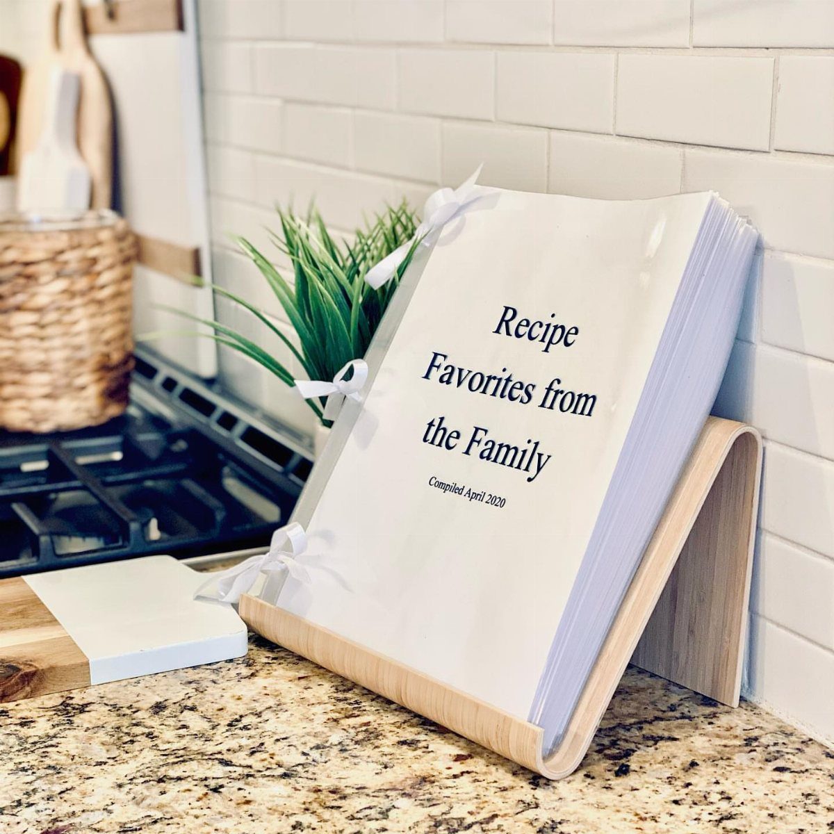 Family recipe binder on a wooden stand on a granite kitchen counter.