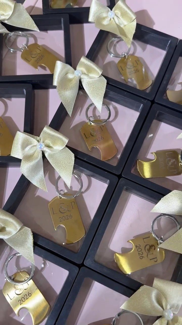 Gold puzzle piece keychains engraved with 2026 in black gift boxes with bows