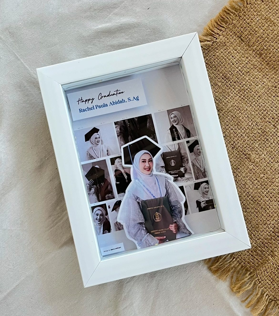 White photo frame containing a graduation photo collage of a woman in regalia.