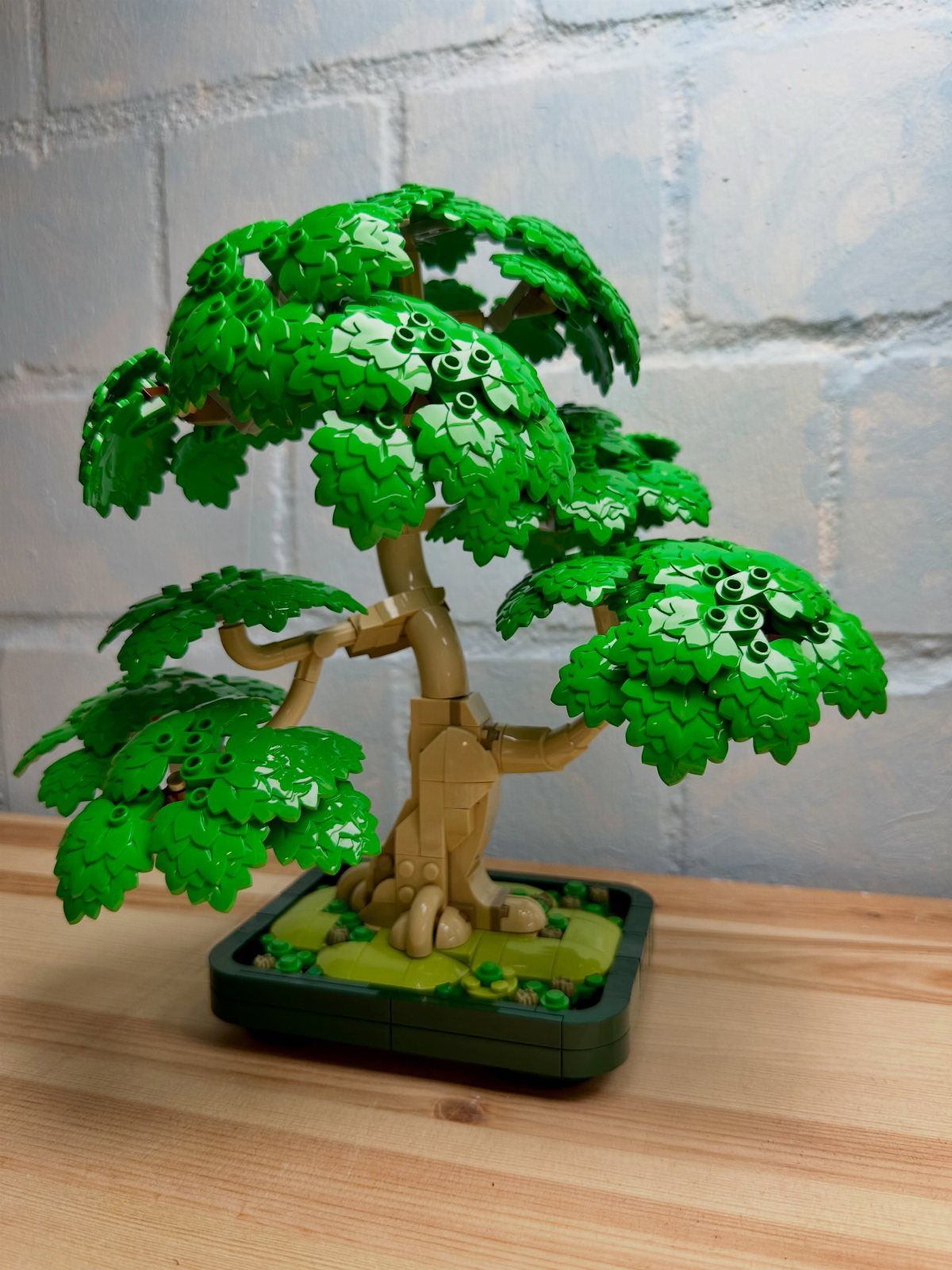 Lego Bonsai Tree with green foliage and tan trunk on a wooden table.