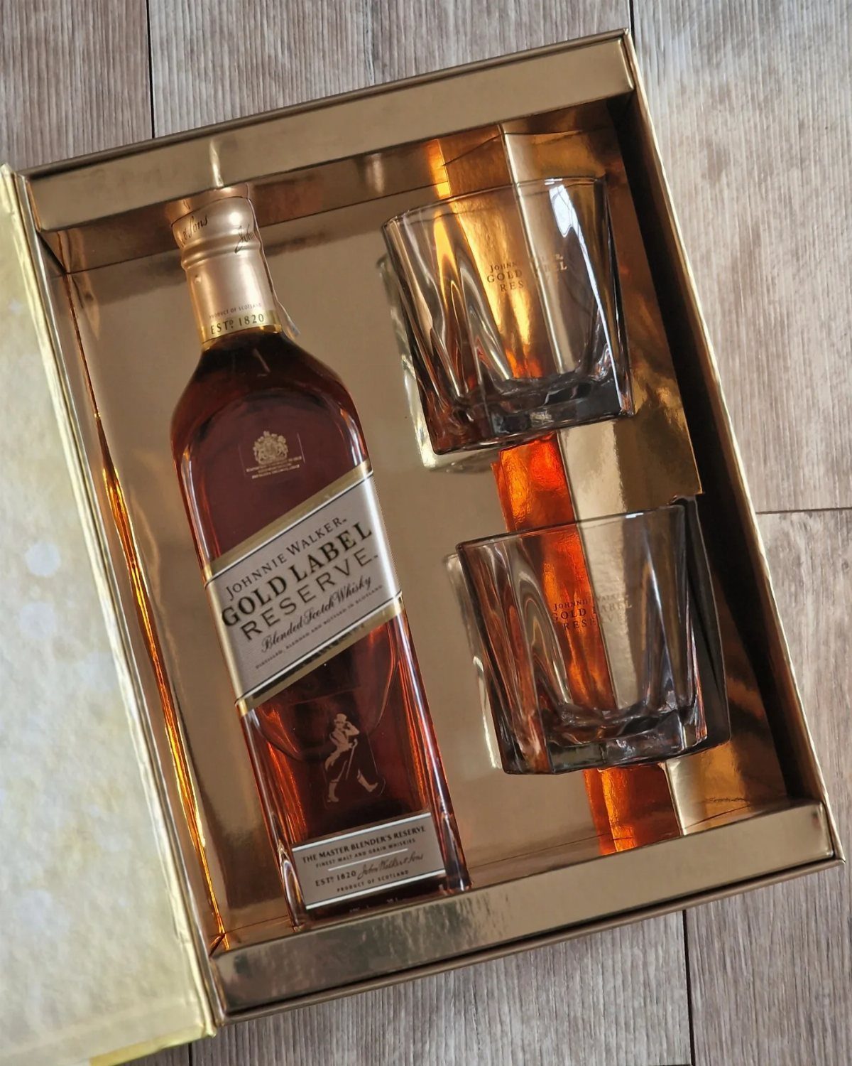 Johnnie Walker Gold Label Reserve whisky bottle and two glasses in a gold box