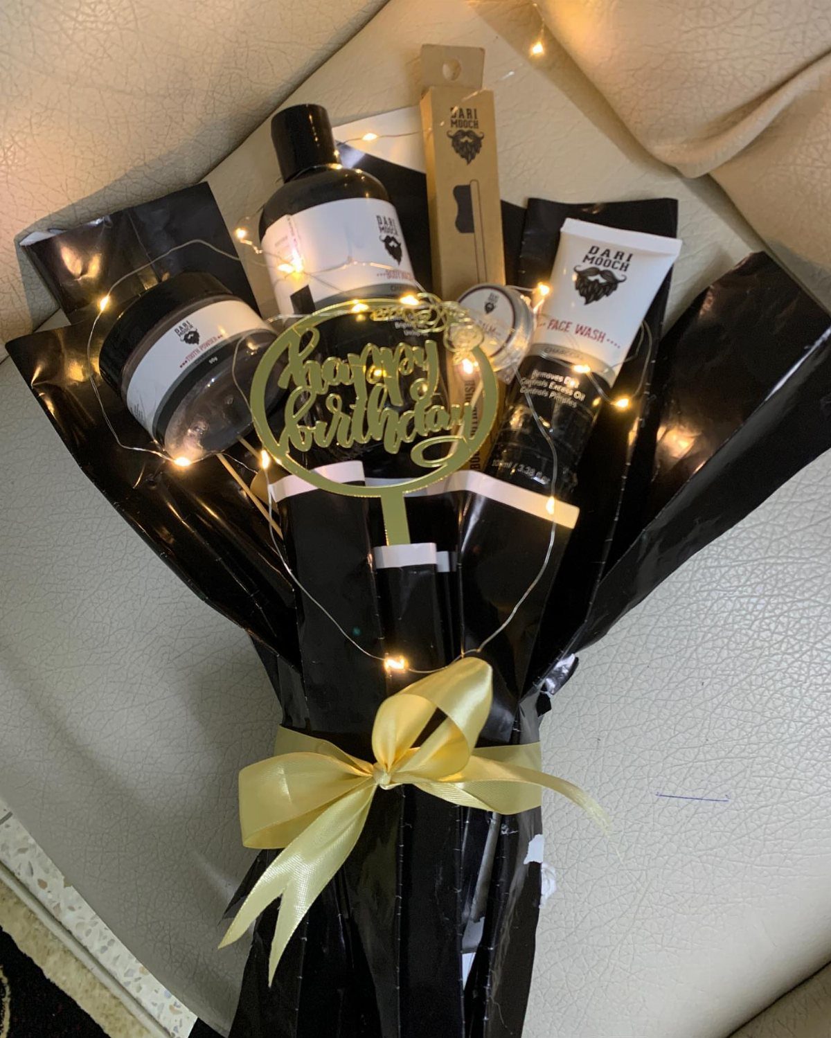 Grooming kit bouquet with face wash and beard products wrapped in black plastic.
