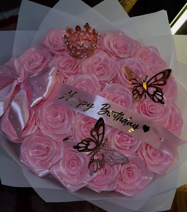 Pink satin rose bouquet with a gold crown and butterflies for a birthday.