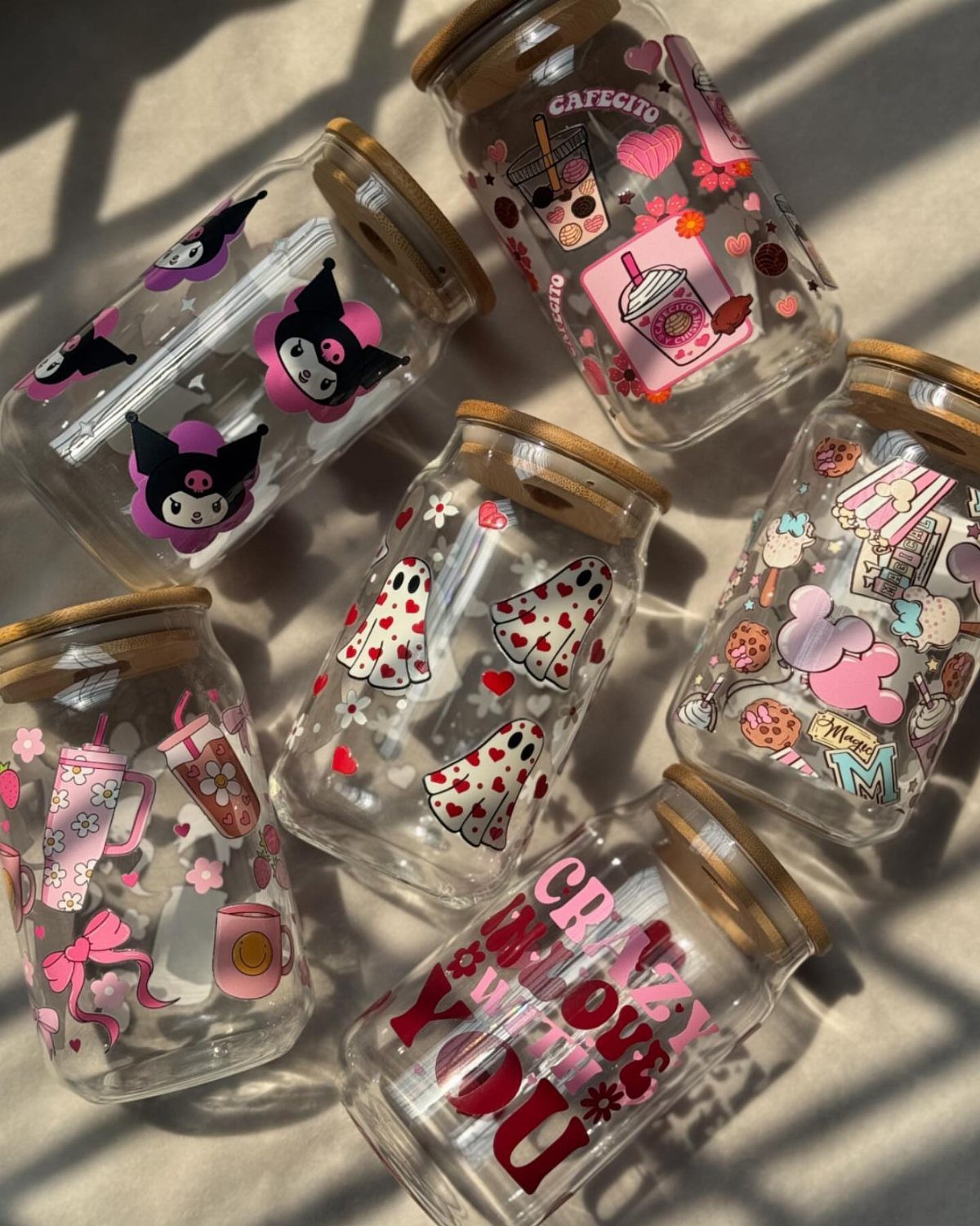 Six decorated glass jars with bamboo lids featuring colorful stickers and illustrations.