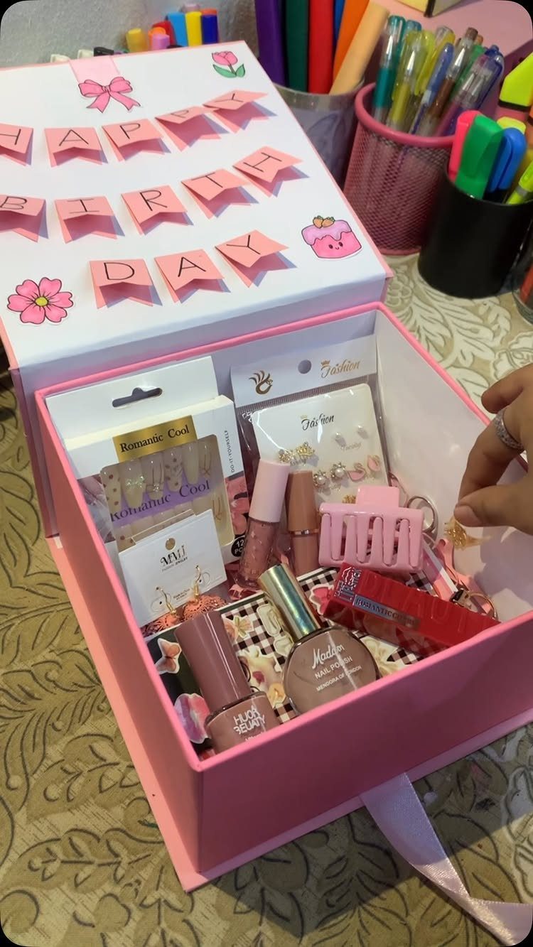 Pink birthday gift box filled with nail polish and beauty care products.