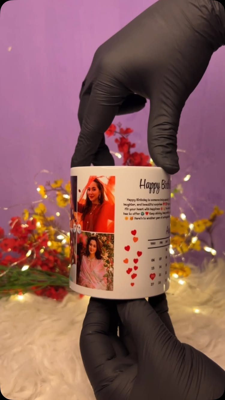 Personalized white birthday mug with photos and hearts held by gloved hands.