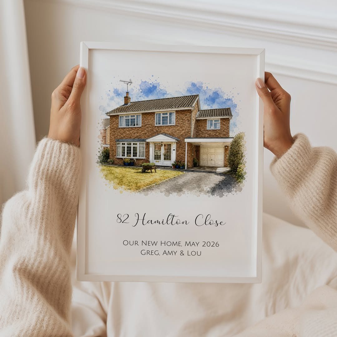 Framed watercolor house portrait with personalized address and names held by a person