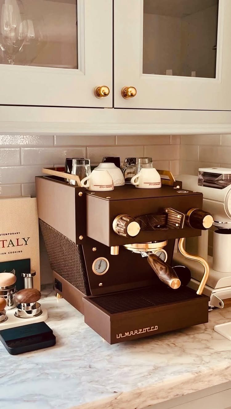 Brown luxury espresso machine with gold accents on a white marble kitchen counter