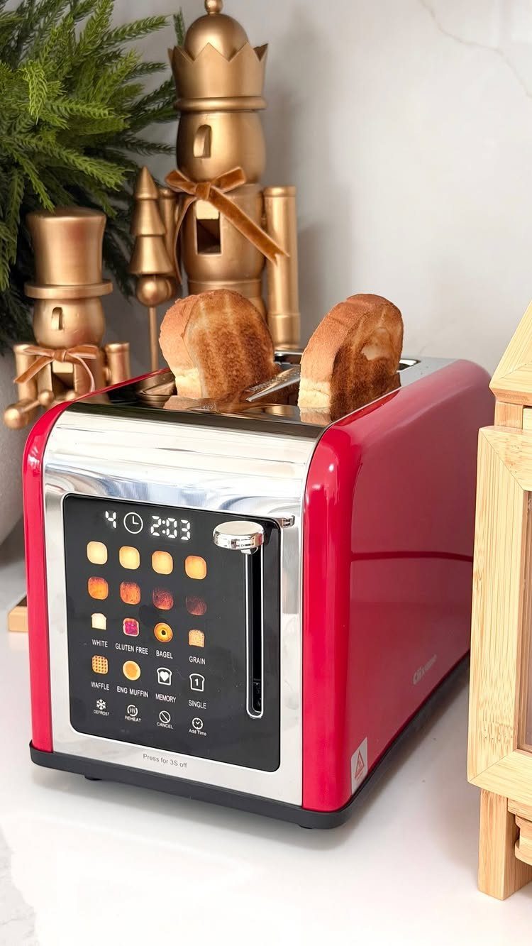 Red smart toaster with digital display and toasted bread on white counter