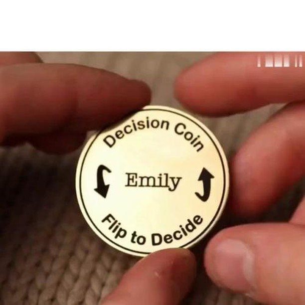 Gold decision coin engraved with the name Emily held between two fingers.