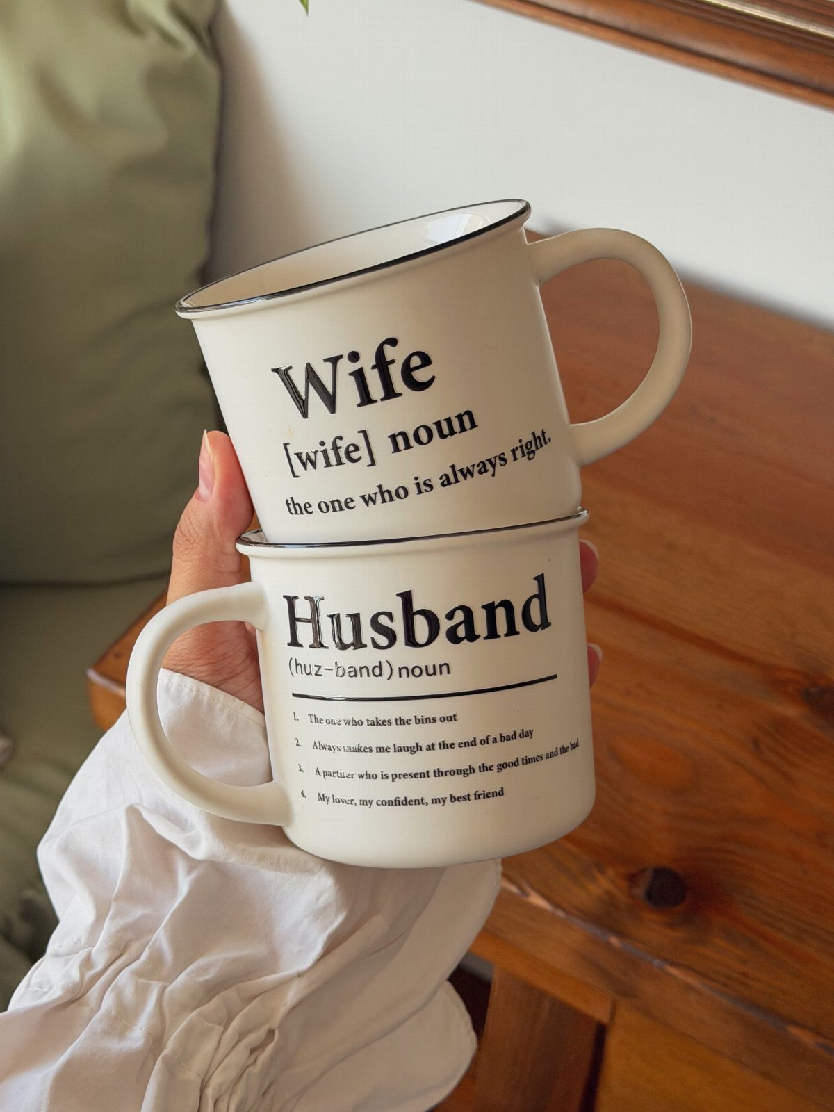 Two white enamel campfire mugs with humorous definitions for wife and husband.