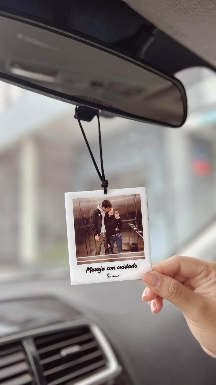 Square photo air freshener hanging from a car rearview mirror showing a couple.