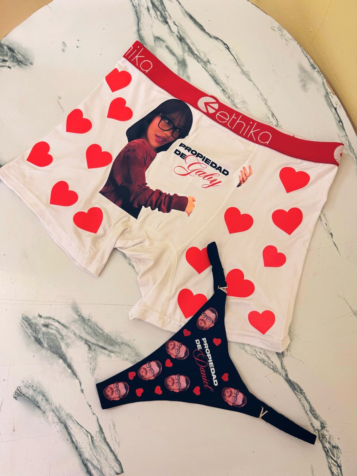 Customized white boxer briefs and black thong featuring photos and red hearts.