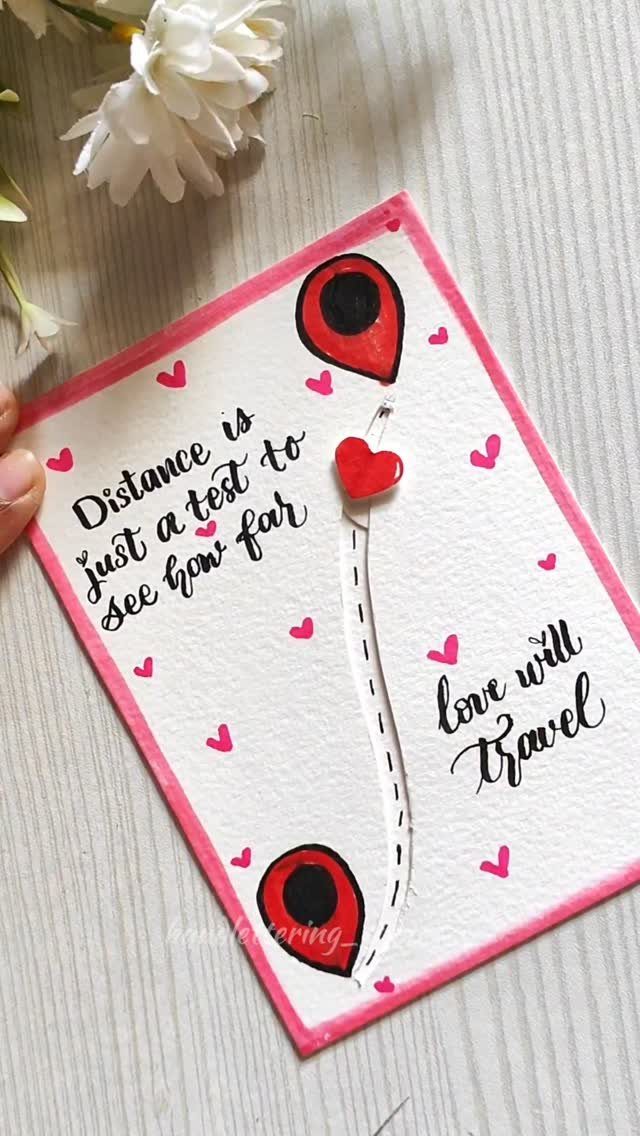 Handmade card with map pins and a heart on a wooden surface