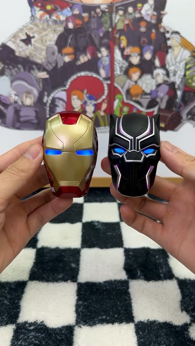 Iron Man and Black Panther glowing mask figurines held by two hands.