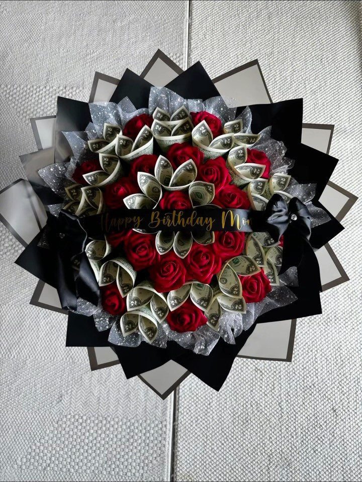 Bouquet of red roses and rolled money wrapped in black and silver paper