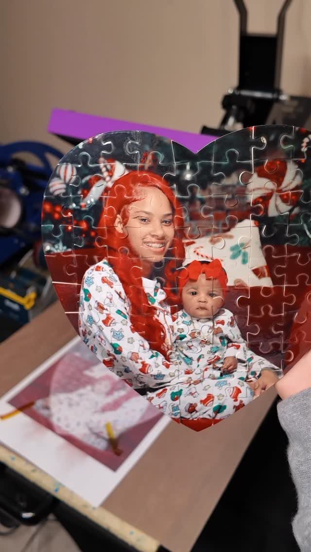 Heart-shaped photo puzzle showing a woman and baby in matching red pajamas.
