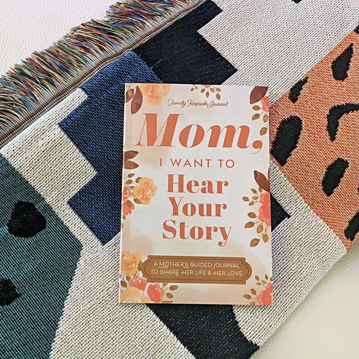 Guided journal for mothers with floral cover on a colorful patterned textile