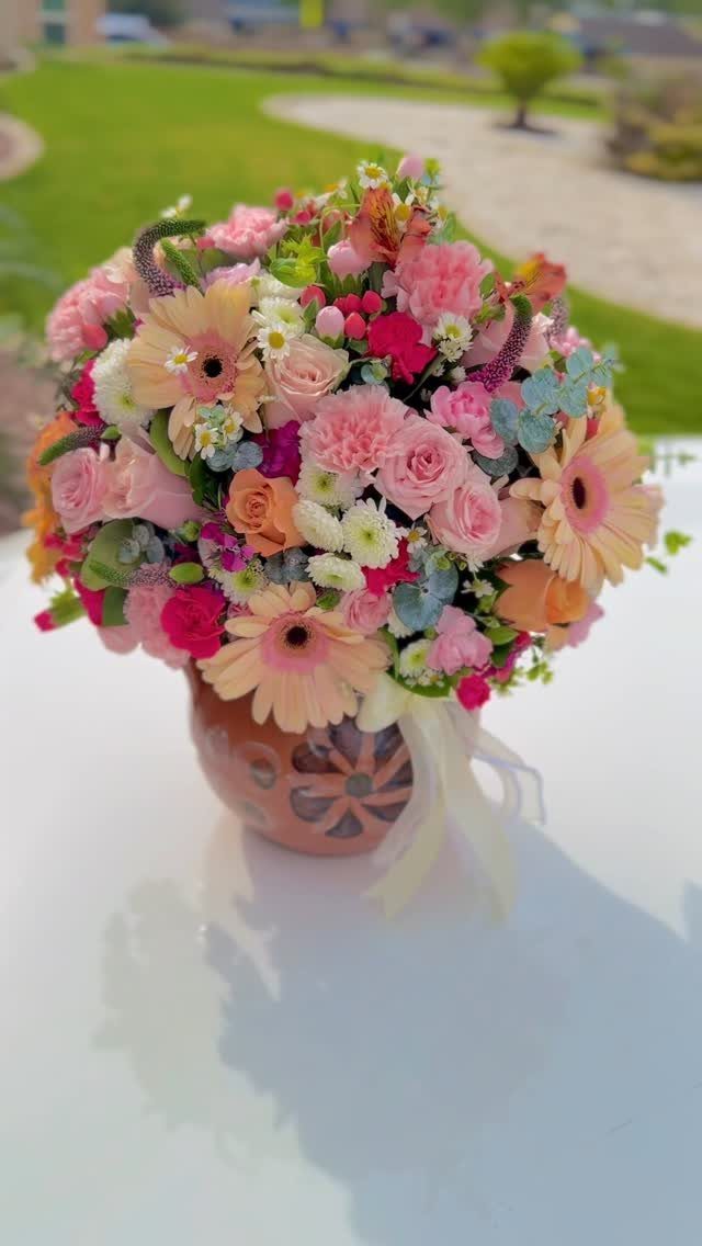 Colorful flower bouquet with pink and orange blooms in a decorative ceramic vase.