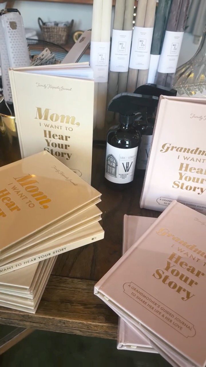 Guided memory journals for mothers and grandmothers stacked on a wooden surface.