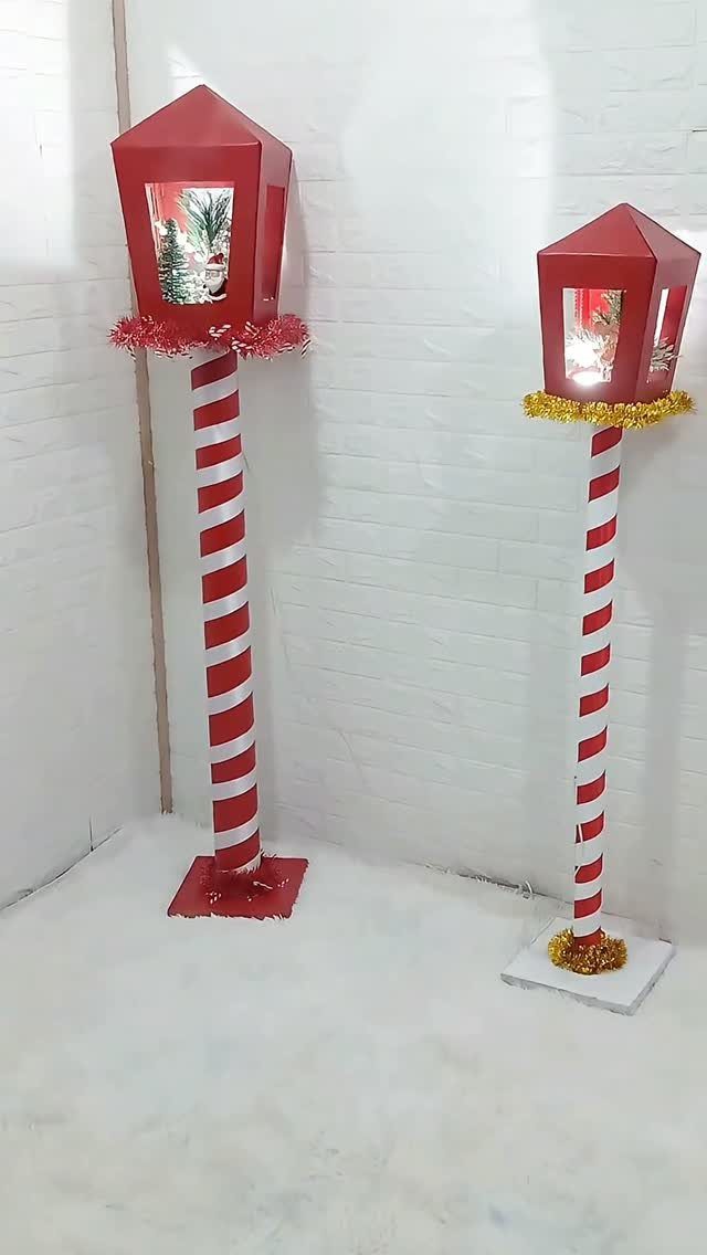 Red lanterns on red and white striped candy cane poles against white brick.