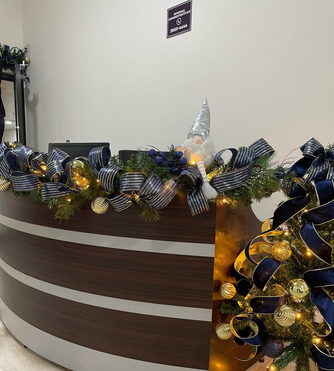 Green pine garland with navy ribbons and gold ornaments on a reception desk