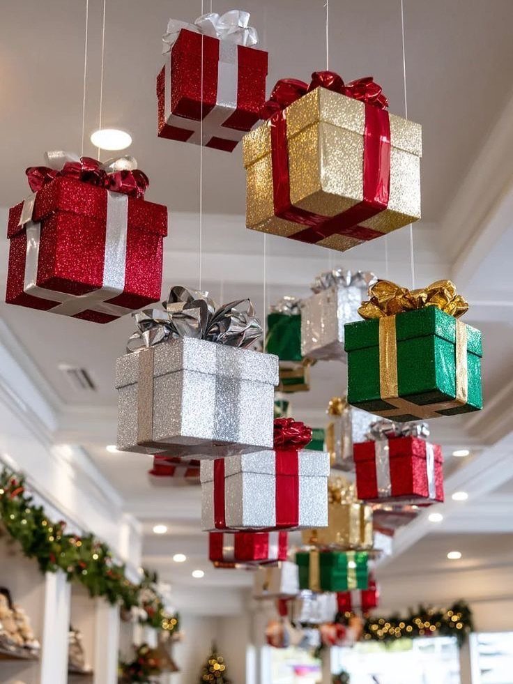 Glittery red, gold, and green gift boxes hanging from a white ceiling.