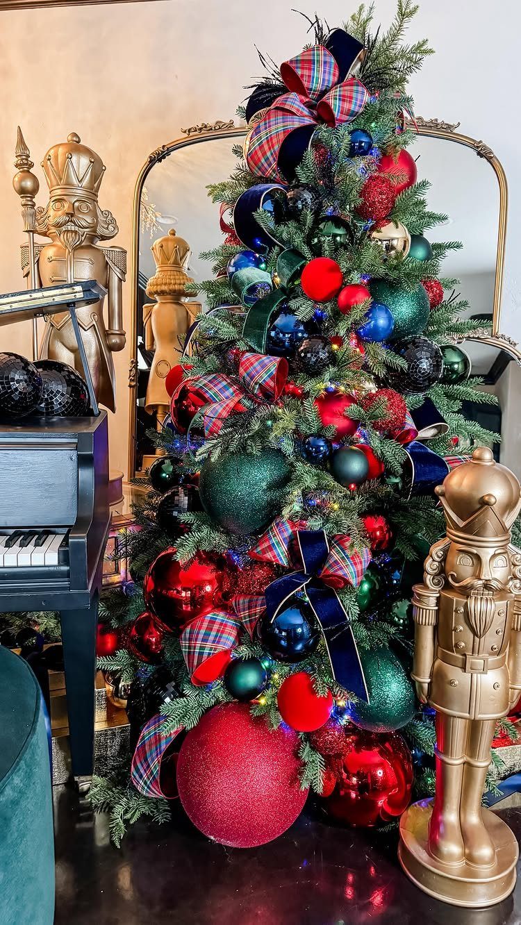 Decorated Christmas tree with red and blue plaid bows and colorful ornaments.