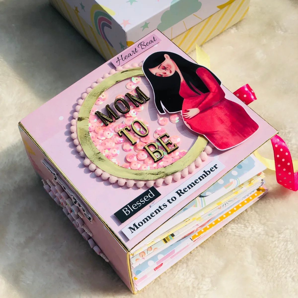 Pink handmade scrapbook for a mother-to-be with sequins and a pregnant woman cutout.