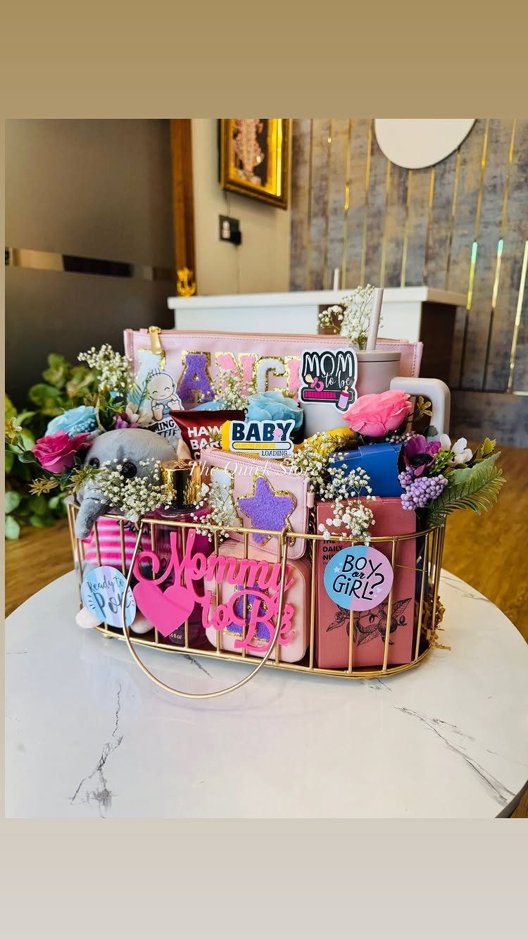 Pregnancy gift basket with pink accessories, flowers, and Mommy to Be sign.