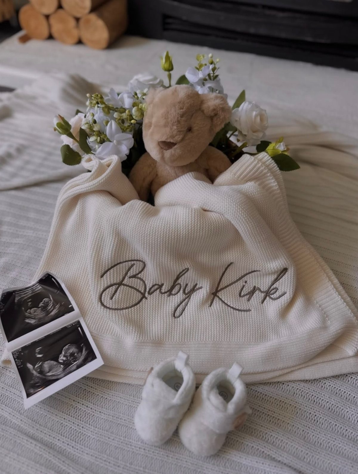 Personalized cream knitted blanket with Baby Kirk embroidery, teddy bear, and baby shoes.