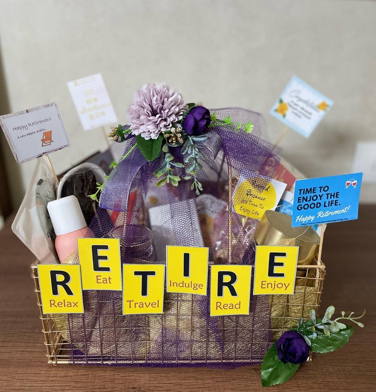 Retirement gift basket with purple flowers and yellow cards spelling out RETIRE