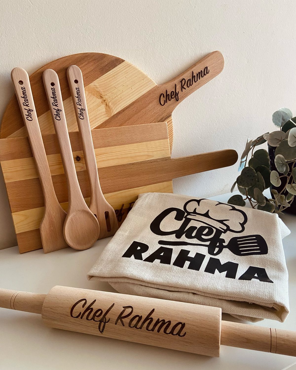 Personalized wooden cooking utensil set and apron engraved with the name Chef Rahma.