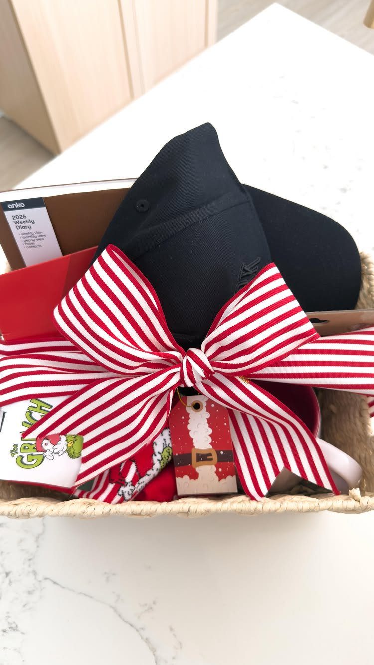 Gift basket with a black cap and Grinch items tied with striped ribbon.