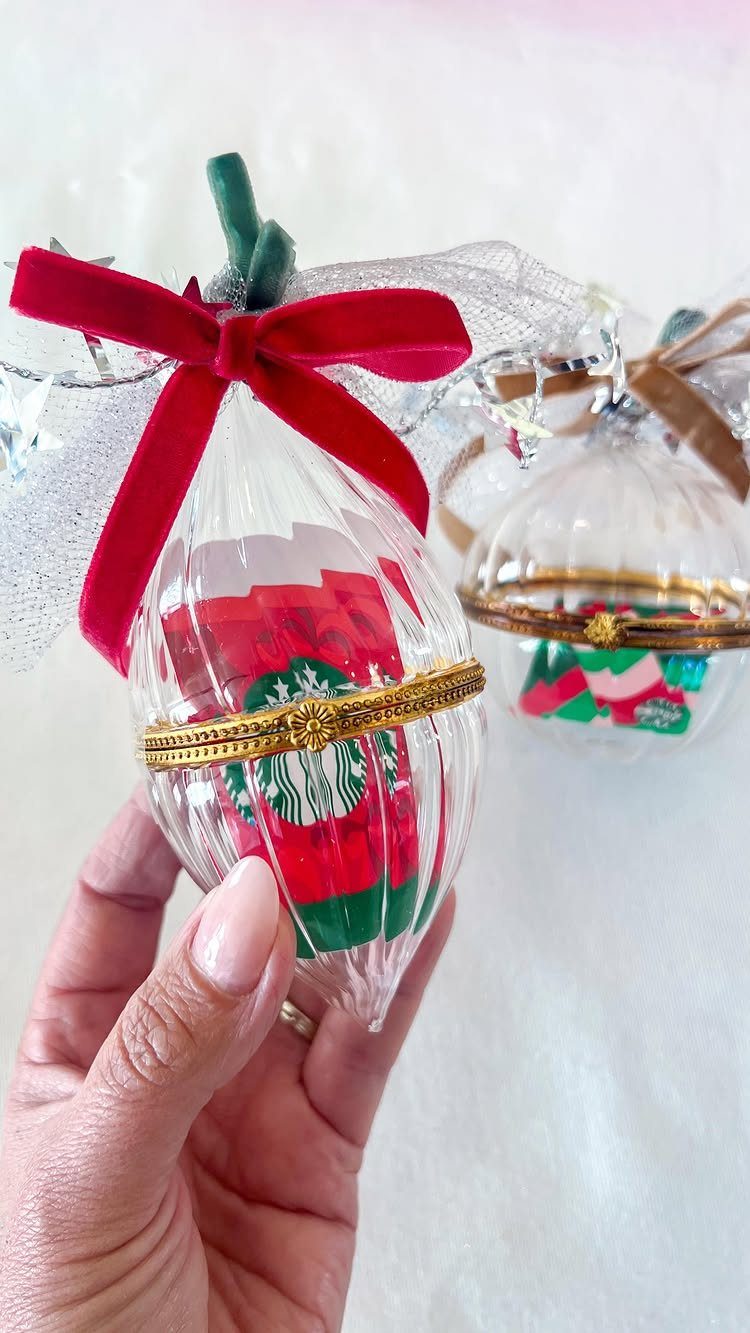Clear glass Christmas ornament containing a red and green Starbucks gift card.