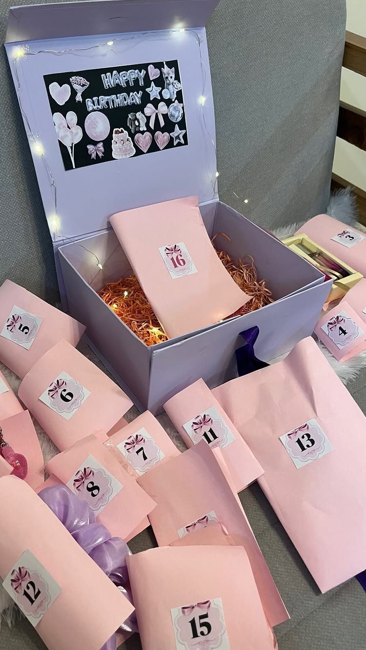 Purple birthday gift box with fairy lights and numbered pink envelopes for sixteen.