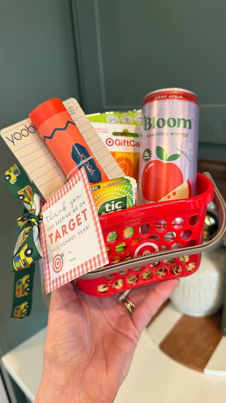 Red gift basket filled with energy drink, gift card, and school supplies.