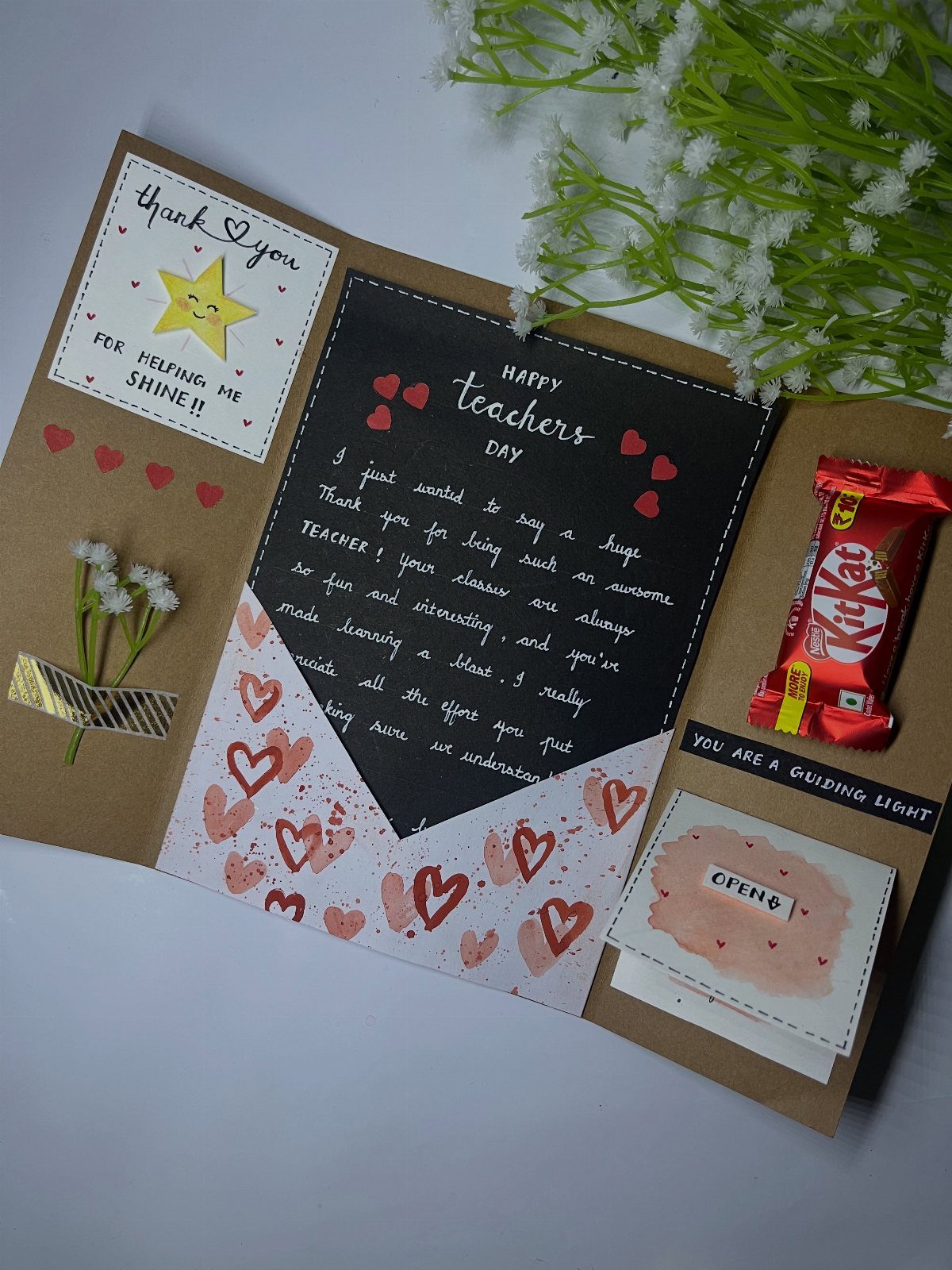 Handmade teacher appreciation card with a handwritten letter, chocolate, and small flowers.