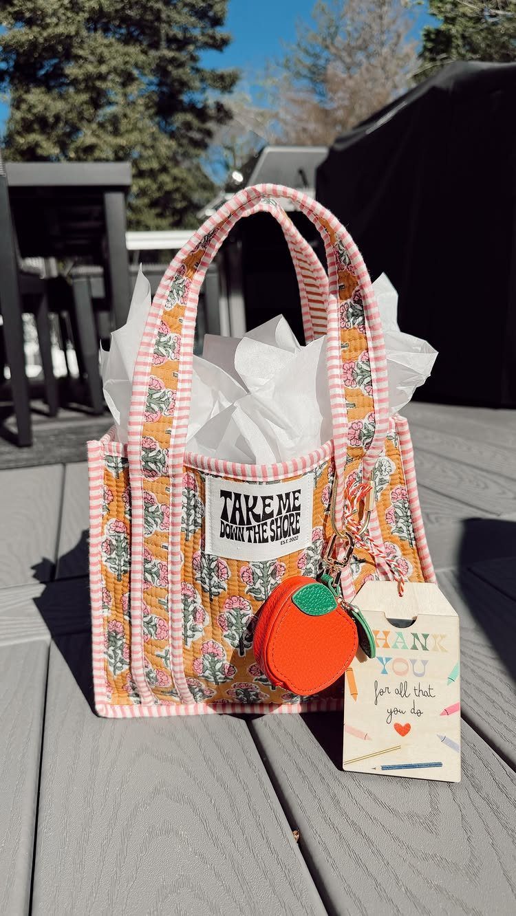 Patterned fabric gift bag with an apple keychain and thank you tag.