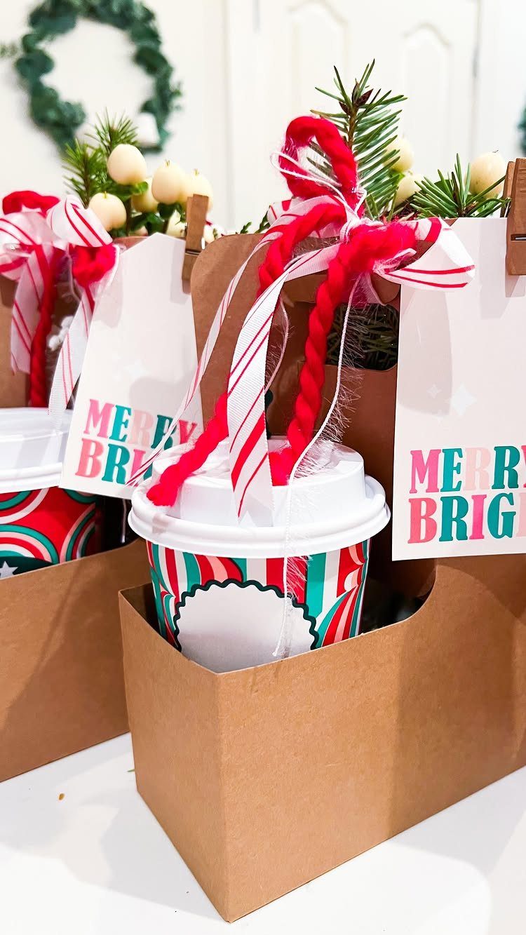 Coffee cups in brown gift bags with candy canes and festive tags.