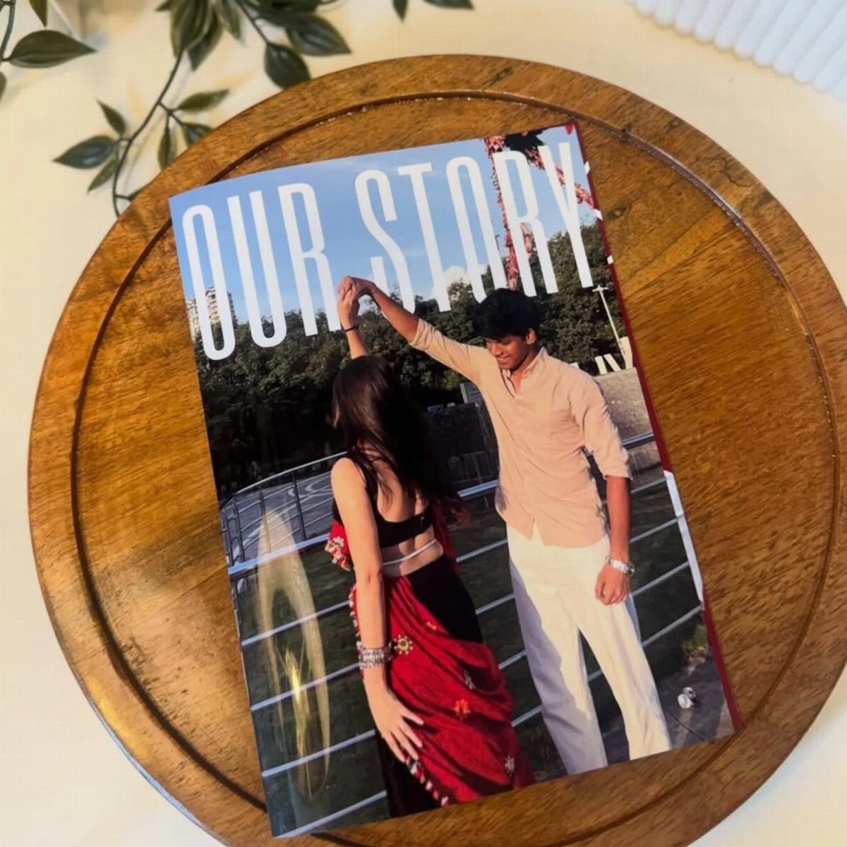 Custom photo book titled Our Story featuring a dancing couple on wooden tray