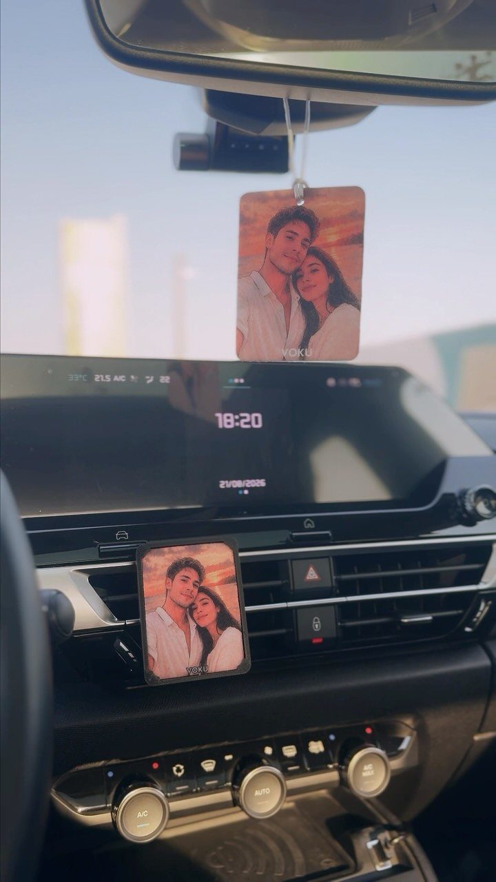Personalized photo car air fresheners hanging from mirror and dashboard vent in car.