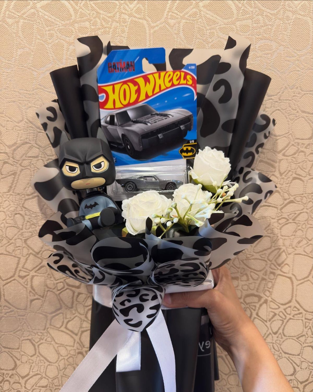 Gift bouquet with Hot Wheels Batman car, Batman figure, and white roses.