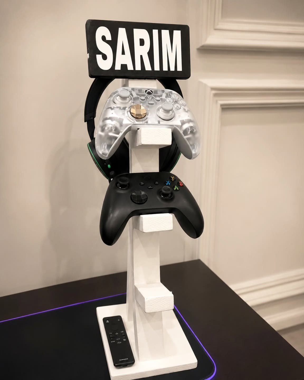 White gaming controller stand holding two controllers with a personalized name sign above.