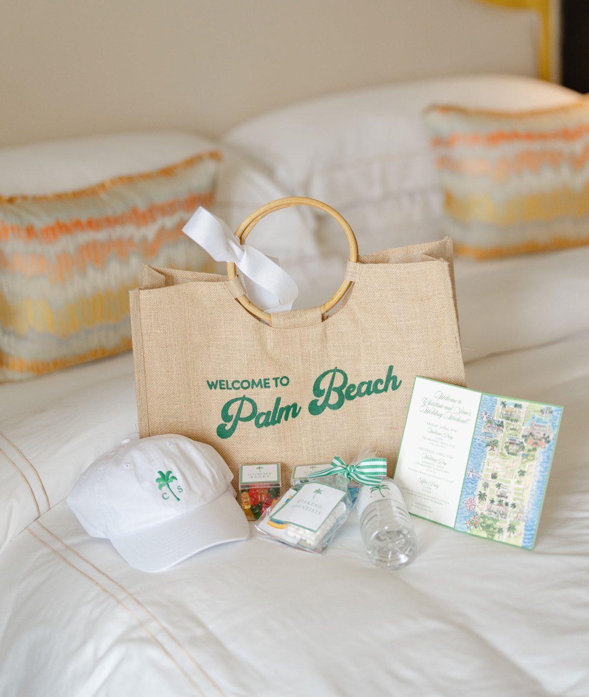 Jute welcome bag with a white cap, water, and itinerary on a bed