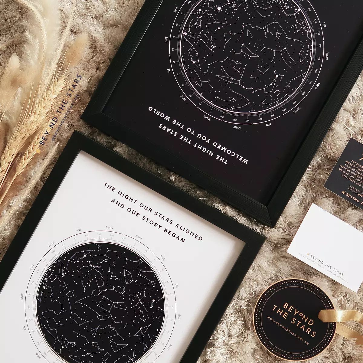 Two framed custom star maps with constellations resting on a fluffy white rug.
