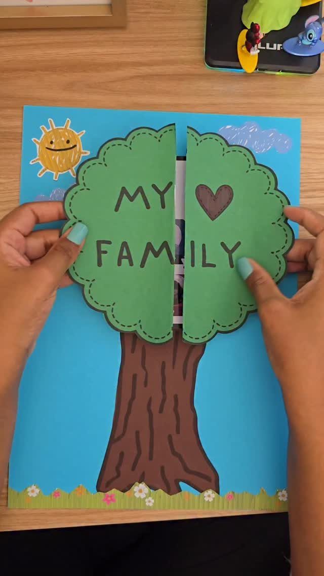 Hands opening a handmade family tree card with a green paper canopy.