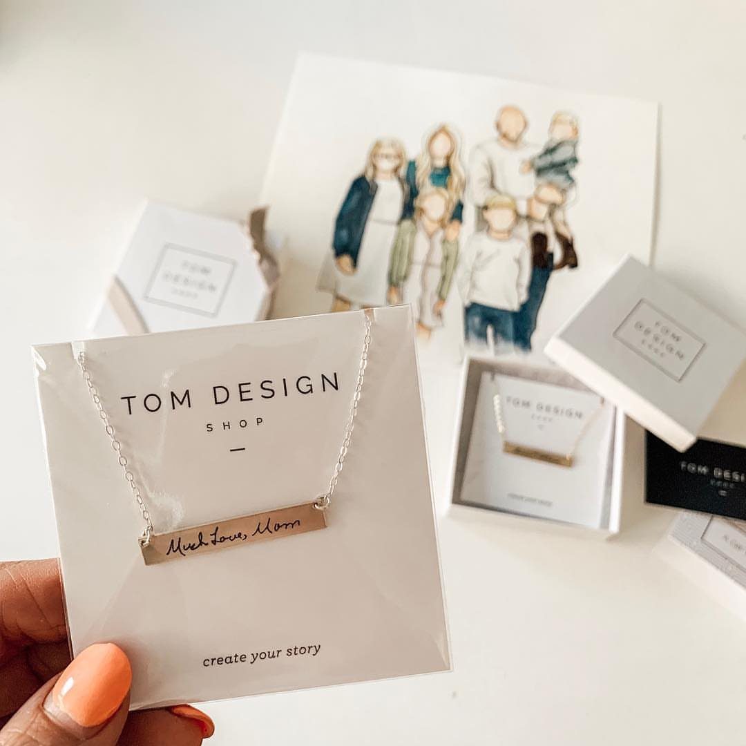 Silver bar necklace with handwritten engraving displayed on a white branded card.