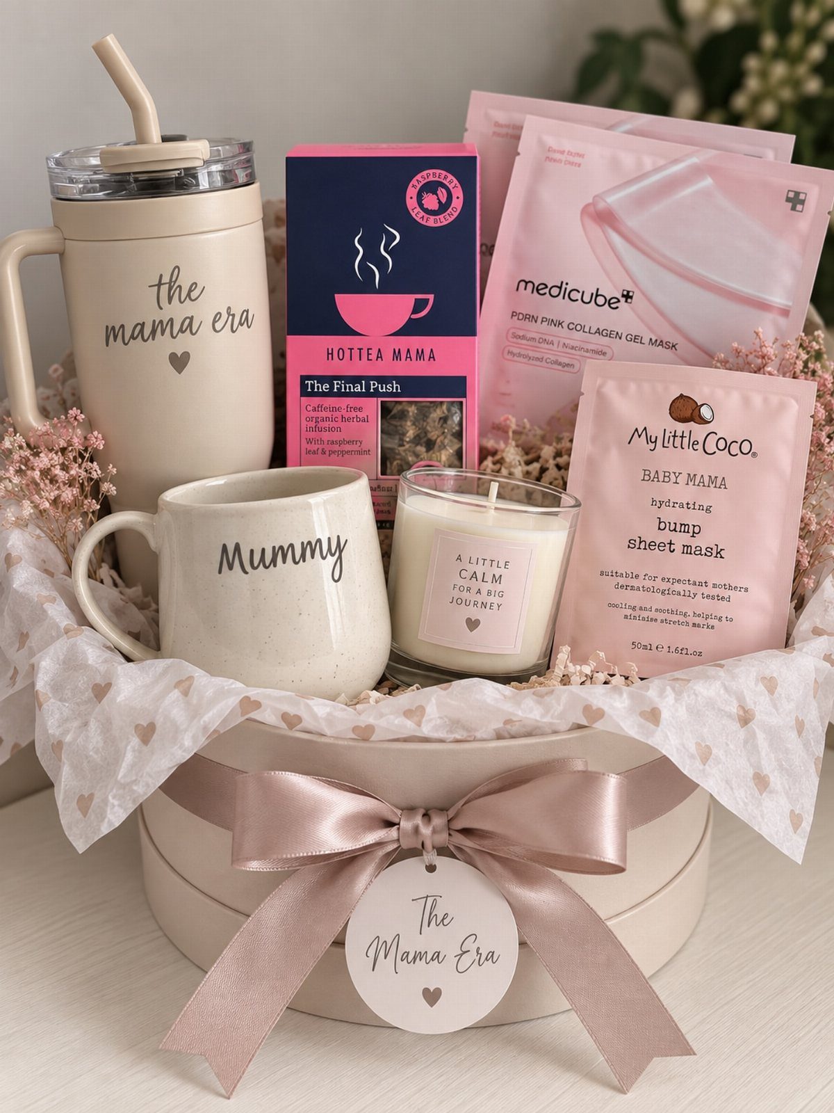 Self-care gift basket with a tumbler, mug, candle, tea, and facial masks.