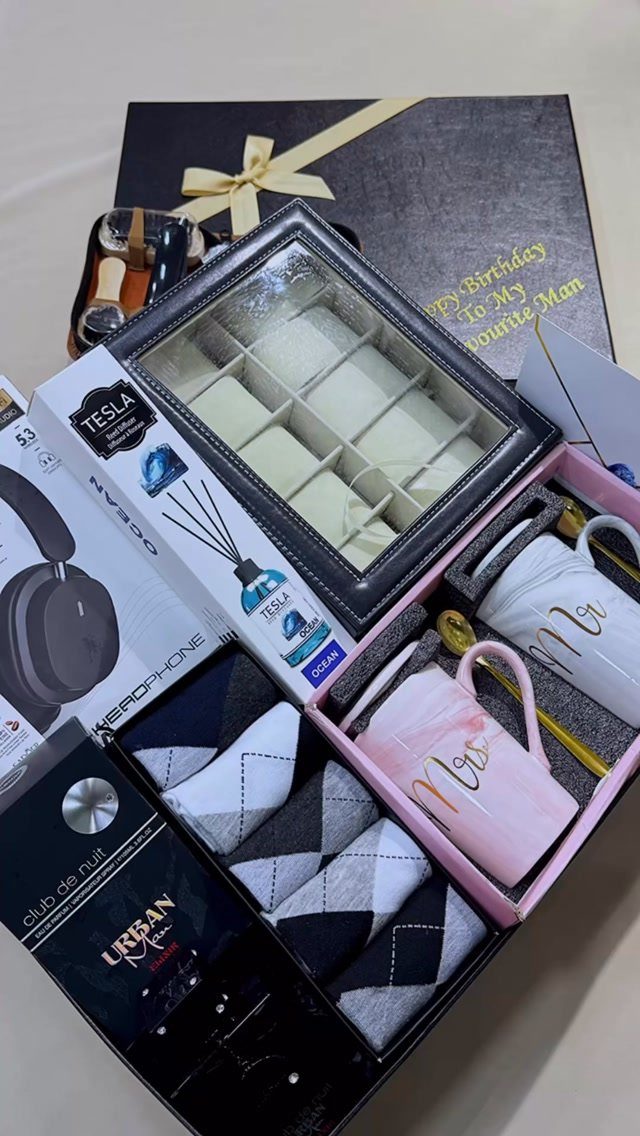 Gift hamper with watch box, Mr and Mrs mugs, socks, and headphones.
